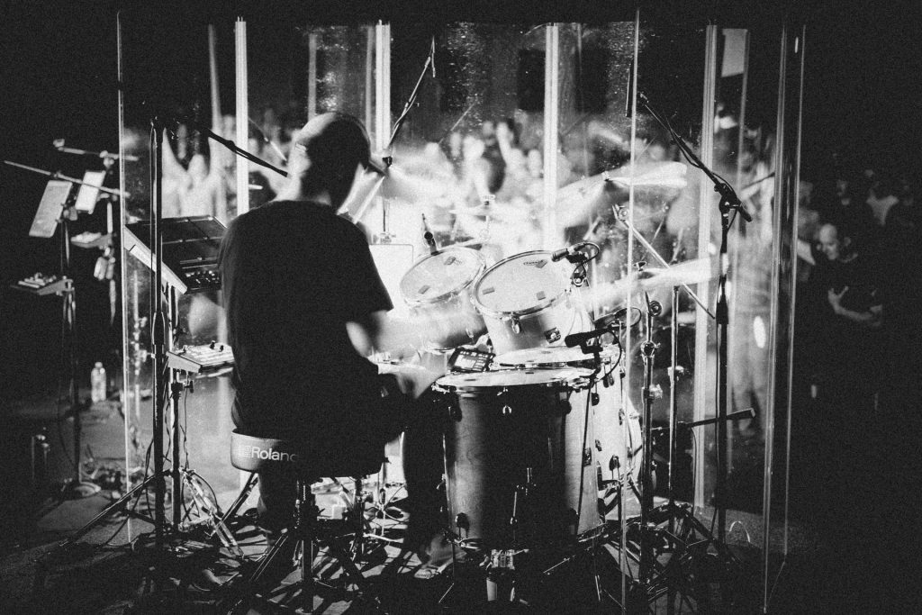 a man playing drums in front of a group of people